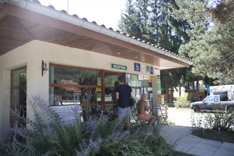 Recepción de Camping de Vaubarlet en Auvergne-Rhône-Alpes, Francia, con personas esperando afuera.