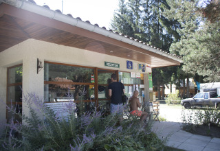 Reception at Camping de Vaubarlet, a holiday park in Auvergne-Rhône-Alpes, France, with people outside.