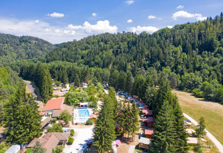 Vista aerea del Camping de Vaubarlet, parco vacanze immerso nei boschi in Auvergne-Rhône-Alpes, Francia.