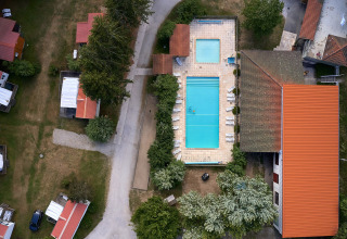 Luchtfoto van Camping de Vaubarlet met zwembaden, rode daken en wandelpaden in Auvergne-Rhône-Alpes, Frankrijk.