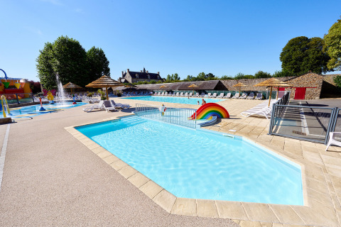 Piscina al aire libre con tumbonas y arcoíris en Camping Domaine du Logis, Bretaña, Francia, en verano.