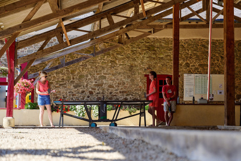 Donna gioca a ping pong sotto una tettoia al Camping Domaine du Logis, Bretagna, Francia.