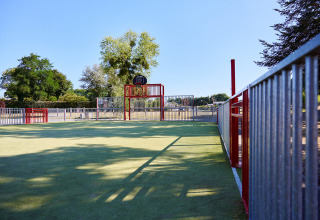Udendørs sportsgård med basketballkurv ved Camping Domaine du Logis, beliggende i Bretagne, Frankrig.