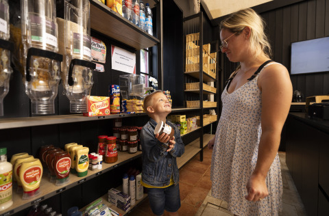Una mujer y un niño compran juntos en una tienda en Camping Domaine du Logis en Bretaña, Francia.