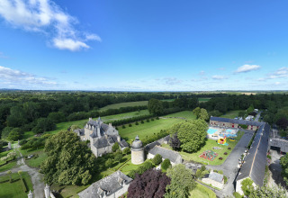 Luftfoto af Camping Domaine du Logis i Bretagne, Frankrig, omgivet af grønne marker og blå himmel.