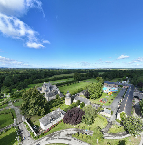 Luftaufnahme vom Camping Domaine du Logis in der Bretagne, Frankreich, mit grünen Feldern und Gebäuden.