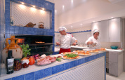 Two chefs preparing pizza at a wood-fired oven in Camping Delle Rose holiday park in Liguria, Italy.