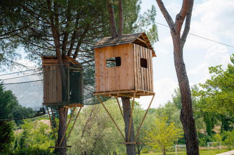 Cabanes dans les arbres reliées par une passerelle au Camping Il Poggetto, Toscane, Italie, au milieu de la nature.