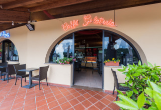 Udendørs terrasse ved Caffè Gelateria på Camping Il Poggetto, en feriepark i Toscana, Italien.