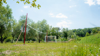 Zona deportiva al aire libre con red de voleibol y porterías en Camping Il Poggetto, Toscana, Italia.
