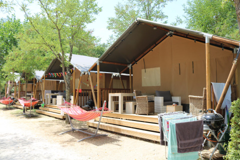 Tiendas glamping con terrazas y hamacas en Camping Il Poggetto, un parque vacacional en la Toscana, Italia.