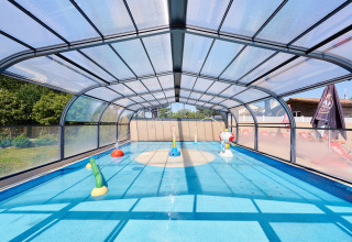 Covered children’s pool with play structures at Camping La Bretonnière holiday park in Pays de la Loire, France.