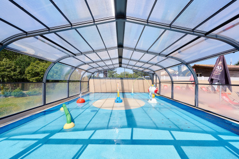 Overdekt kinderzwembad met speelelementen bij Camping La Bretonnière, vakantiepark in Pays de la Loire, Frankrijk.
