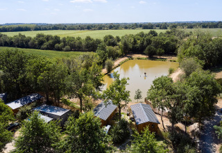 Aerial view of Camping La Bretonnière holiday park in Pays de la Loire, France, showing cabins and a pond.