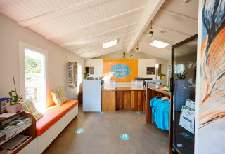 Receptionen på Camping La Bretonnière, lyse farver, informationsbrochurer og afslappet ferieatmosfære.