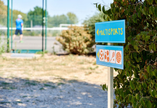 Cartello multipsport a Camping La Bretonnière, Pays de la Loire, Francia, vicino a un campo da tennis.