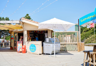 Camping La Bretonnière feriepark i Pays de la Loire, Frankrig. Iskiosk under parasol i solskinsvejr.