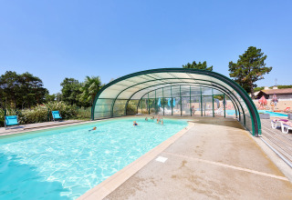 Outdoor swimming pool with partial cover at Camping La Bretonnière in Pays de la Loire, France.