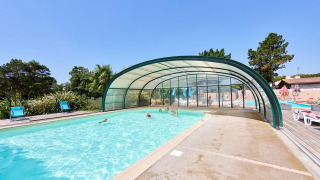 Outdoor swimming pool with partial cover at Camping La Bretonnière in Pays de la Loire, France.