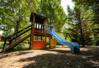 Speeltuin met glijbaan en klimtoren bij Camping La Chiocciola, vakantiepark in het Toscaanse landschap, Italië.