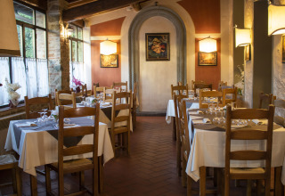 Gezellig restaurant met gedekte tafels en houten stoelen in Camping La Chiocciola, Toscane, Italië.