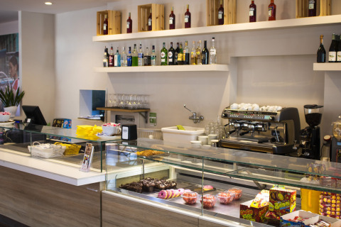 Cafetería moderna con pasteles, dulces y bebidas en Camping La Chiocciola, parque vacacional en Toscana, Italia.