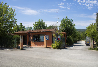 Ingang van Camping La Chiocciola in Toscane, Italië, met receptie en toegangspad te zien.
