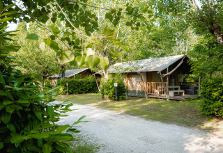 Lodge tents at Camping La Chiocciola in Tuscany, Italy, surrounded by lush greenery and natural beauty.