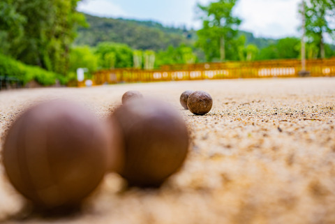 Bocce da pétanque su un campo di ghiaia al Camping La Clémentine, Occitania, Francia, all'aperto.
