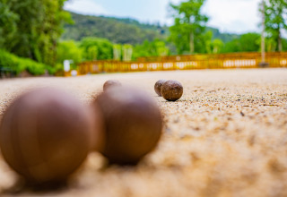 Bocce da pétanque su un campo di ghiaia al Camping La Clémentine, Occitania, Francia, all'aperto.