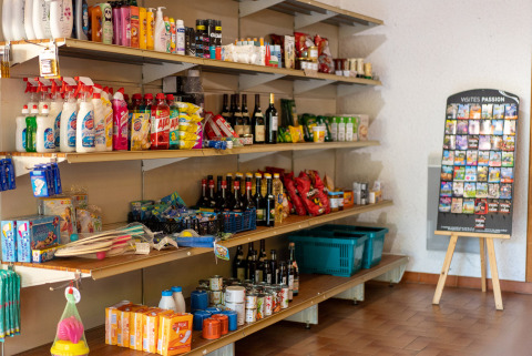 Estantes de tienda con productos de limpieza, alimentos y vinos en Camping La Clémentine de Occitania, Francia.