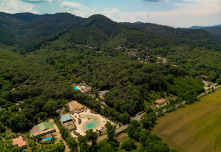 Vista aerea del villaggio vacanze Camping La Clémentine immerso tra le colline boscose dell'Occitania, Francia.