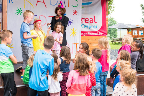 Niños disfrutando de un espectáculo en el escenario en Camping La Colline, parque vacacional en Bélgica-Luxemburgo.