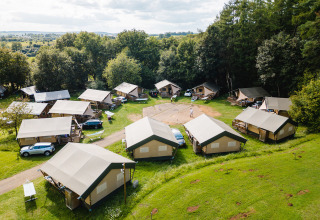 Luchtbeeld van Camping La Colline met safaritenten, auto's en groen in Belgisch Luxemburg, België.