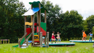 Niños jugando en el parque infantil de Camping La Colline, un parque de vacaciones en Bélgica Luxemburgo, Bélgica.