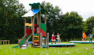 Niños jugando en el parque infantil de Camping La Colline, un parque de vacaciones en Bélgica Luxemburgo, Bélgica.