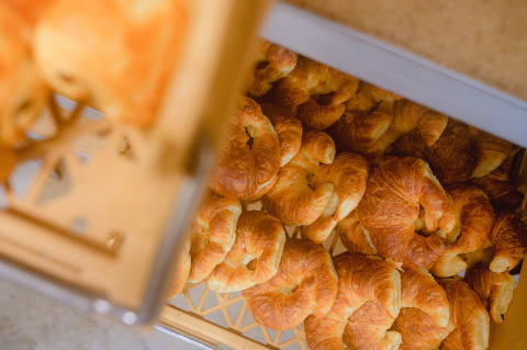 Croissants recién horneados en bandeja de plástico en Camping La Colline, parque vacacional en Bélgica Luxemburgo.