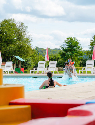 Niños jugando en una piscina con bloques de construcción de colores en primer plano en Camping La Colline, Bélgica.