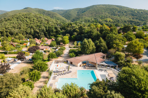 Vista aerea del campeggio La Garenne con piscina e colline verdi in Auvergne-Rhône-Alpes, Francia.