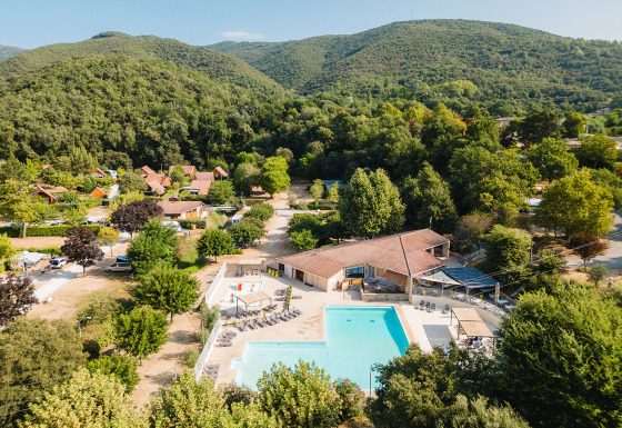 Luftfoto af Camping La Garenne feriepark med swimmingpool og grønne bakker i Auvergne-Rhône-Alpes, Frankrig.