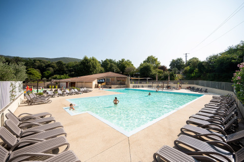 Außenpool mit Liegestühlen und Gästen im Ferienpark Camping La Garenne in Auvergne-Rhône-Alpes, Frankreich.