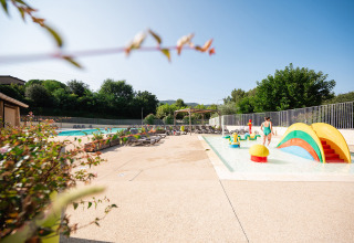 Børnevenligt poolområde med farverige legeredskaber og liggestole på Camping La Garenne i Frankrig.
