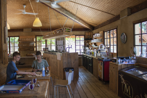 Dos chicos juegan a un juego de mesa en una sala de madera en Camping La Garenne, Auvernia-Ródano-Alpes, Francia.