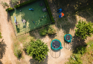 Luftaufnahme eines Spielplatzes und Trampolinen im Camping La Garenne, Auvergne-Rhône-Alpes, Frankreich.