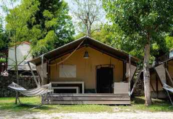 Safari-Zelt Villatent Wood auf dem Campingplatz Il Poggetto in Italien mit Veranda und Hängematte.
