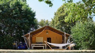 Tienda safari Villatent Nomad en Camping La Bretonnière, Francia, vista exterior con hamaca delante.