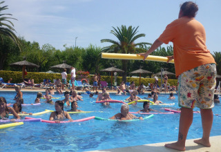 Aqua aerobics class taking place in the pool at Camping La Masia, Catalonia, Spain, with many participants.