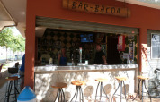 Udendørs barområde på Camping La Masia, Catalonien, Spanien, med besøgende og bartender bag disken.