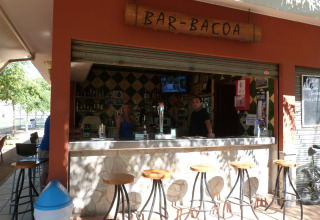 Außenbar im Camping La Masia, Katalonien, Spanien, mit Gästen und Barkeepern hinter der Theke.