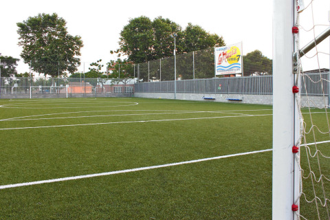 Fußballplatz im Ferienpark Camping La Masia in Katalonien, Spanien, mit grünem Rasen und Tor.